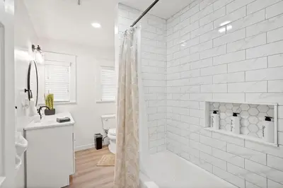 a white bathroom with a shower and a toilet at 1 mile from the Beach Fire Pit, Patio, Parking! in Long Beach