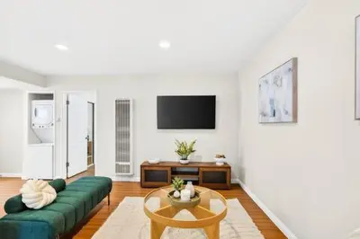a living room with a green couch and a table at Prime Manhattan Beach 2BR Walk to Beach with Parking in Manhattan Beach
