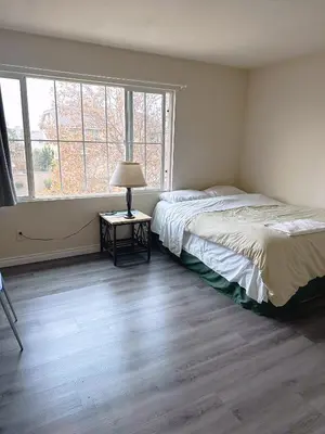 a bedroom with a bed and a lamp on a table at Big quiet bedroom in Hacienda Heights