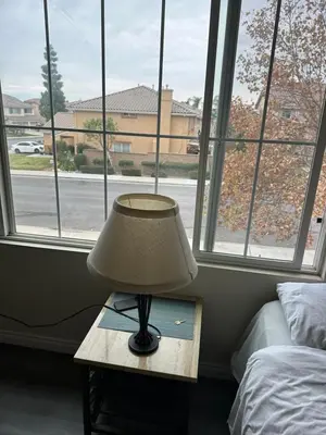 a lamp on a table in front of a window at Big quiet bedroom in Hacienda Heights