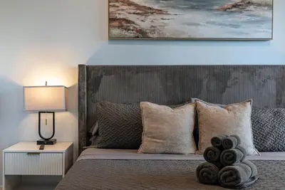 a bedroom with a bed with a painting above it at Brand New 2BR Loft near Universal & Hollywood in Los Angeles