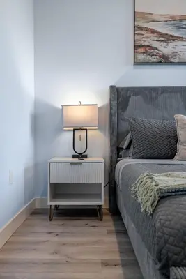 a bedroom with a bed and a lamp on a night stand at Brand New 2BR Loft near Universal & Hollywood in Los Angeles