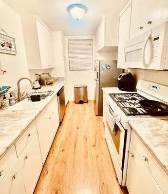 a kitchen with white cabinets and a wooden floor at Beach lovely home in Santa Monica in Los Angeles