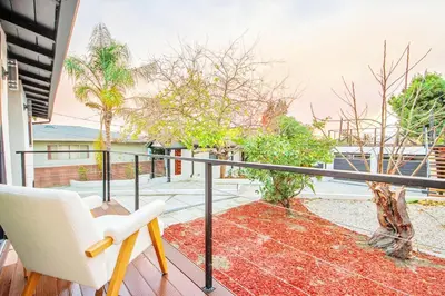 a balcony with a white chair and a view of the ocean at 2 Units Oasis Villa w terrace&roofdeck 12 pax in Los Angeles