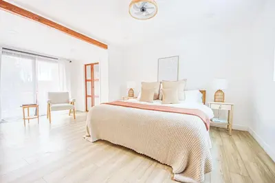 a white bedroom with a bed and a clock on the wall at 2 Units Oasis Villa w terrace&roofdeck 12 pax in Los Angeles