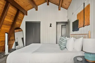 a bedroom with a large white bed with pillows at Arrowbear Retreat - EV Charging, Generator, Arcade in Arrowbear Lake