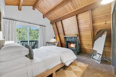 a bedroom with a fireplace and a bed in front of it at Arrowbear Retreat - EV Charging, Generator, Arcade in Arrowbear Lake