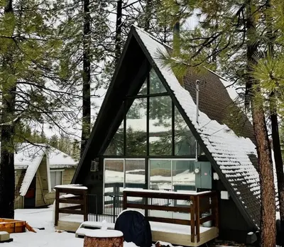a cabin in the woods with snow on the roof at The Highpoint - Close to Lake/Village, Fireplace, Smart TV, Hammock, BBQ in Big Bear Lake