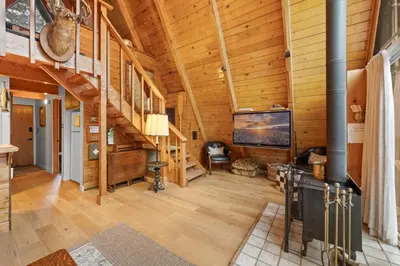 a large living room with wooden walls and wooden floors at The Highpoint - Close to Lake/Village, Fireplace, Smart TV, Hammock, BBQ in Big Bear Lake
