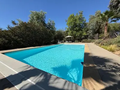 a swimming pool in a backyard with a blue at Airstream at Tree Ranch Grove Paradise in Ojai