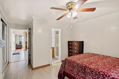 a bedroom with a ceiling fan and a red bed at Fireplace Evenings • Smart TV • Sleeps 7 in Carson