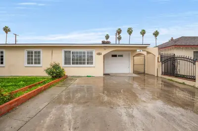 a house with a garage and palm trees at Fireplace Evenings • Smart TV • Sleeps 7 in Carson
