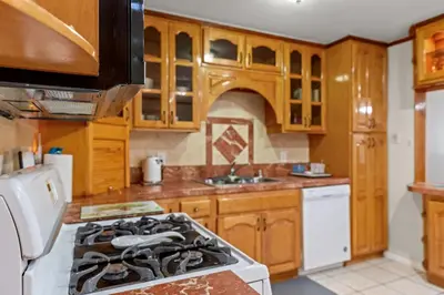 a kitchen with wooden cabinets and a stove top oven at Fireplace Evenings • Smart TV • Sleeps 7 in Carson