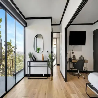 a bedroom with a bed and a desk and a mirror at Skyview Estate in Los Angeles