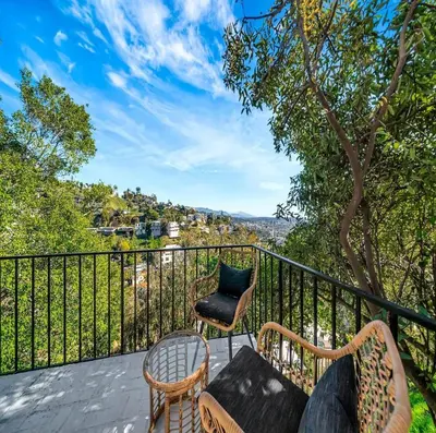 a balcony with two chairs and a table and a chair at Skyview Estate in Los Angeles