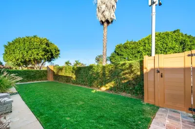 a garden with a fence and a palm tree at 5 STAR BEAUTIFUL LONG BEACH HOuSE in Long Beach