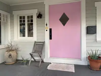 a pink front door of a house with a chair at Charming Boho Pasadena Cottage Near Rose Bowl in Pasadena
