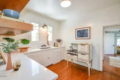 a kitchen with white counters and a stove top oven at Charming Boho Pasadena Cottage Near Rose Bowl in Pasadena