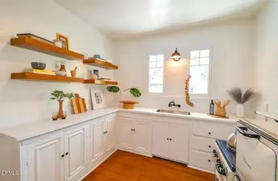 a kitchen with white cabinets and a sink at Charming Boho Pasadena Cottage Near Rose Bowl in Pasadena