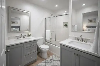 a white bathroom with two sinks and a toilet at Irolo Guesthouse in Los Angeles
