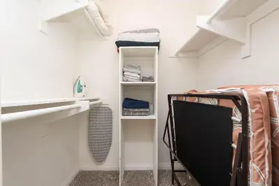 a bedroom with white walls and a bed and shelves at Polished 1BR Hollywood Apt w Rooftop Pool & Views in Los Angeles