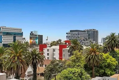 a city skyline with palm trees and buildings at Polished 1BR Hollywood Apt w Rooftop Pool & Views in Los Angeles