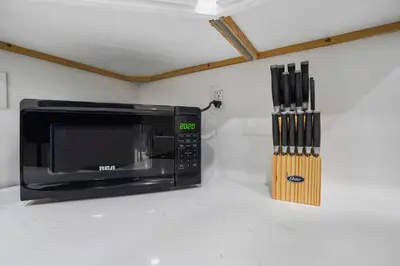 a microwave sitting on a counter next to some knives at Walk to Shoreline Village, BBQ in Prime Location in Long Beach