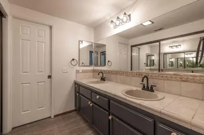 a bathroom with two sinks and two mirrors at Lakeview Getaway Game Rm, Pool, Spa, Sauna! in Big Bear Lake