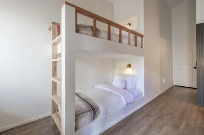 a white bedroom with a bunk bed in it at Lakeview Getaway Game Rm, Pool, Spa, Sauna! in Big Bear Lake