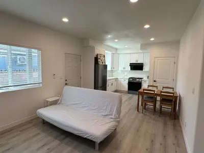 a bedroom with a bed and a table and a kitchen at Brand New Muji Style 3B3B Retreat with Courtyard in Walnut