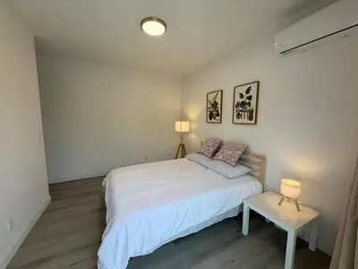 a bedroom with a white bed and a table at Brand New Muji Style 3B3B Retreat with Courtyard in Walnut
