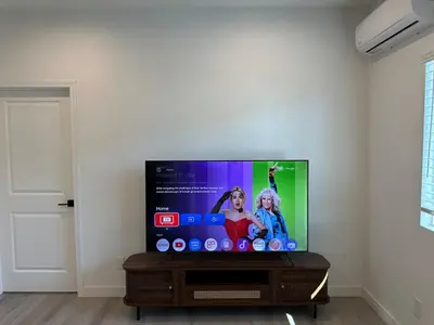 a flat screen tv sitting on a stand in a living room at Brand New Muji Style 3B3B Retreat with Courtyard in Walnut
