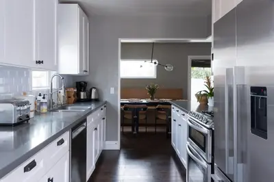 a kitchen with white cabinets and stainless steel appliances at Lovely Culver City Home 8 Mins to Beach Close to LAX in Los Angeles