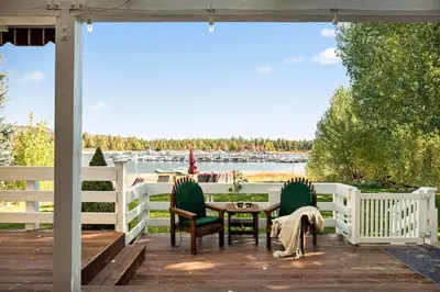 a porch with a table and chairs and a view of the water at Home Sweet Home in Big Bear Lake