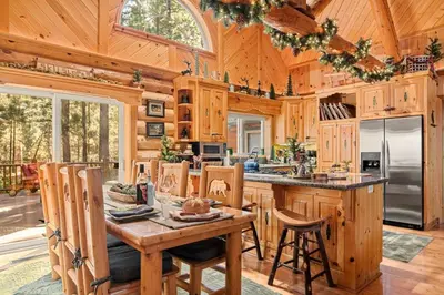 a kitchen with a table and chairs in a cabin at Honeycomb Hideaway in Big Bear Lake