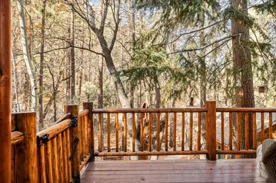 a wooden deck with a wooden fence in the woods at Honeycomb Hideaway in Big Bear Lake