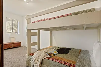 a bedroom with two bunk beds in a room at Solstice Shores Chalet, Hot Tub and Lake Views in Fawnskin