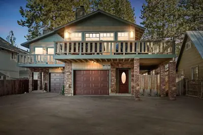 a large house with a deck and a garage at Live Love Lake in Big Bear Lake