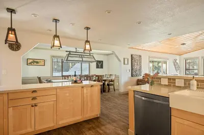 a large kitchen with wooden cabinets and a dining room at Live Love Lake in Big Bear Lake