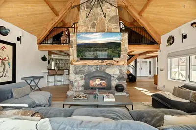 a living room with a stone fireplace in a house at Seuss by the Shore in Big Bear Lake