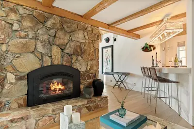 a fireplace in a living room with a stone wall at Seuss by the Shore in Big Bear Lake