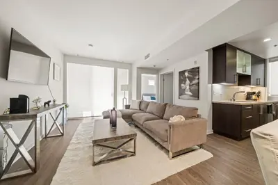 a living room with a couch and a kitchen at Heart of Santa Monica Chic Condo in Los Angeles