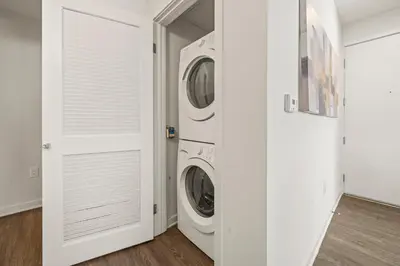 a white laundry room with a washer and dryer at Heart of Santa Monica Chic Condo in Los Angeles