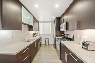 a kitchen with wooden cabinets and a sink and a stove at Heart of Santa Monica Chic Condo in Los Angeles