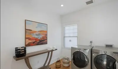 a laundry room with a washing machine and a painting at Hollywood Heritage Villa in Los Angeles
