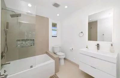 a white bathroom with a tub and a toilet and a sink at Beautiful home with VIEWS in Silver Lake Hills in Los Angeles