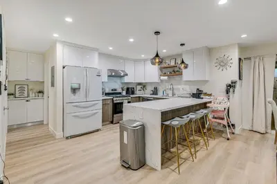 a kitchen with white cabinets and a white refrigerator at 20 min to Disneyland - Spacious Family Home Near All the Fun in Westminster