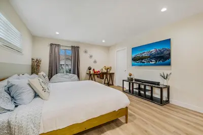 a bedroom with a bed and a television in it at 20 min to Disneyland - Spacious Family Home Near All the Fun in Westminster