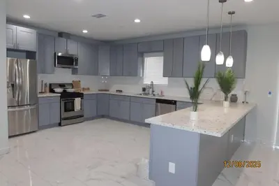 a large kitchen with blue cabinets and a counter top at Welcome to A new updated 3 bedroom 2 Bath Home in California City