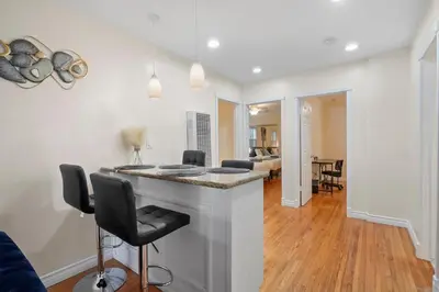 a kitchen and living room with a bar with chairs at Steps to the Beach - Games - Free Parking in Long Beach